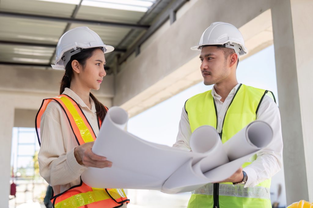 Engineers Reviewing Construction Blueprints on Site. Design and Coordination